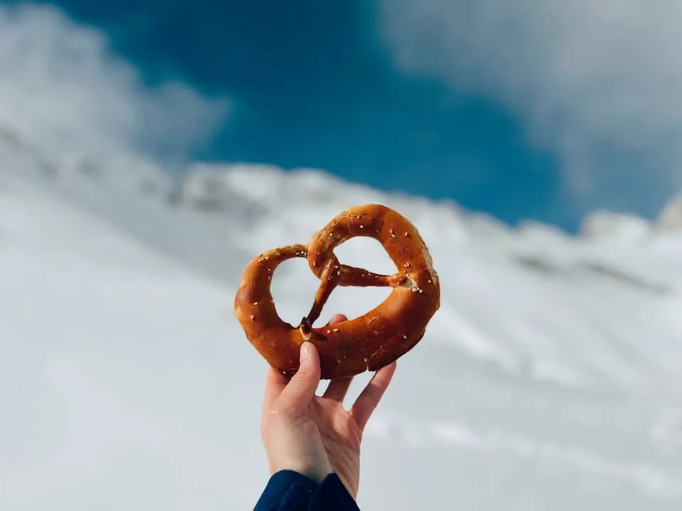 female hand holding pretzel, one of the popular street food - Chef's Deal