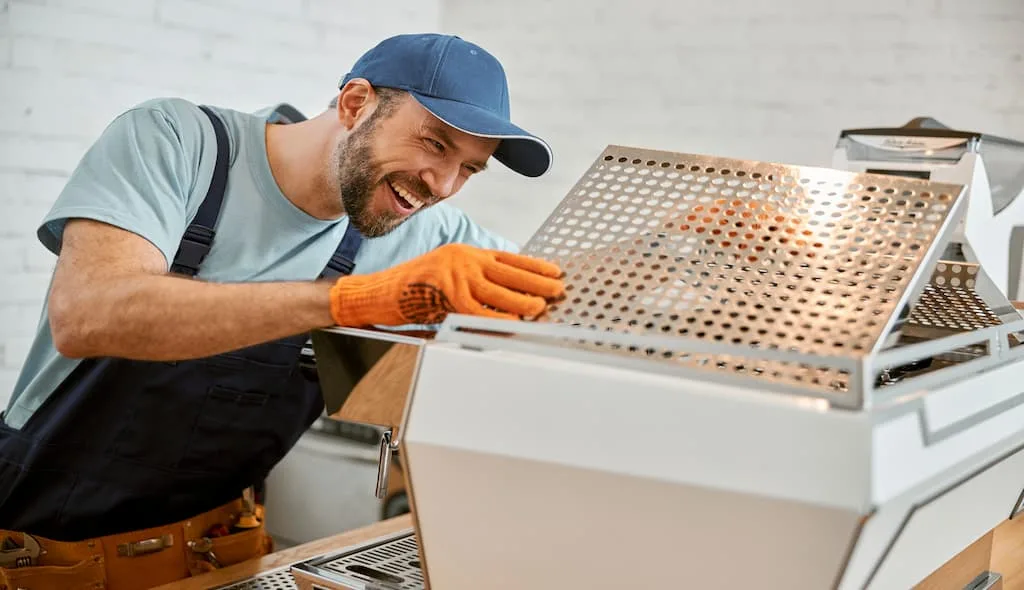 A pro maintenance personnel is doing regular checks of an commercial kitchen equipment. - Outsourcing Commercial Kitchen Equipment Maintenance